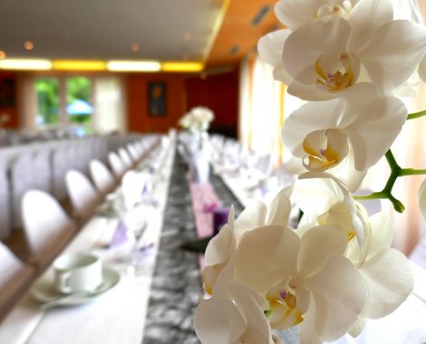 Gedeckte Tischtafel mit einer Orchidee im Vordergrund im Restaurant Hotel Imhof in Gemünden